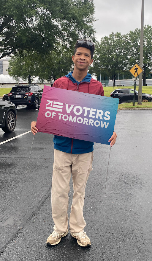 Elijah holding a Voters of Tomorrow sign